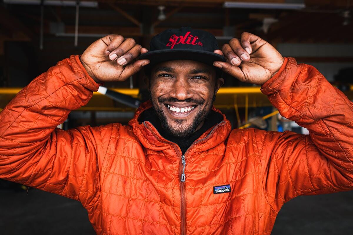 Portrait of professional snowboarder Ryan Hudson smiling looking into the camera wearing an orange Patagonia jacket