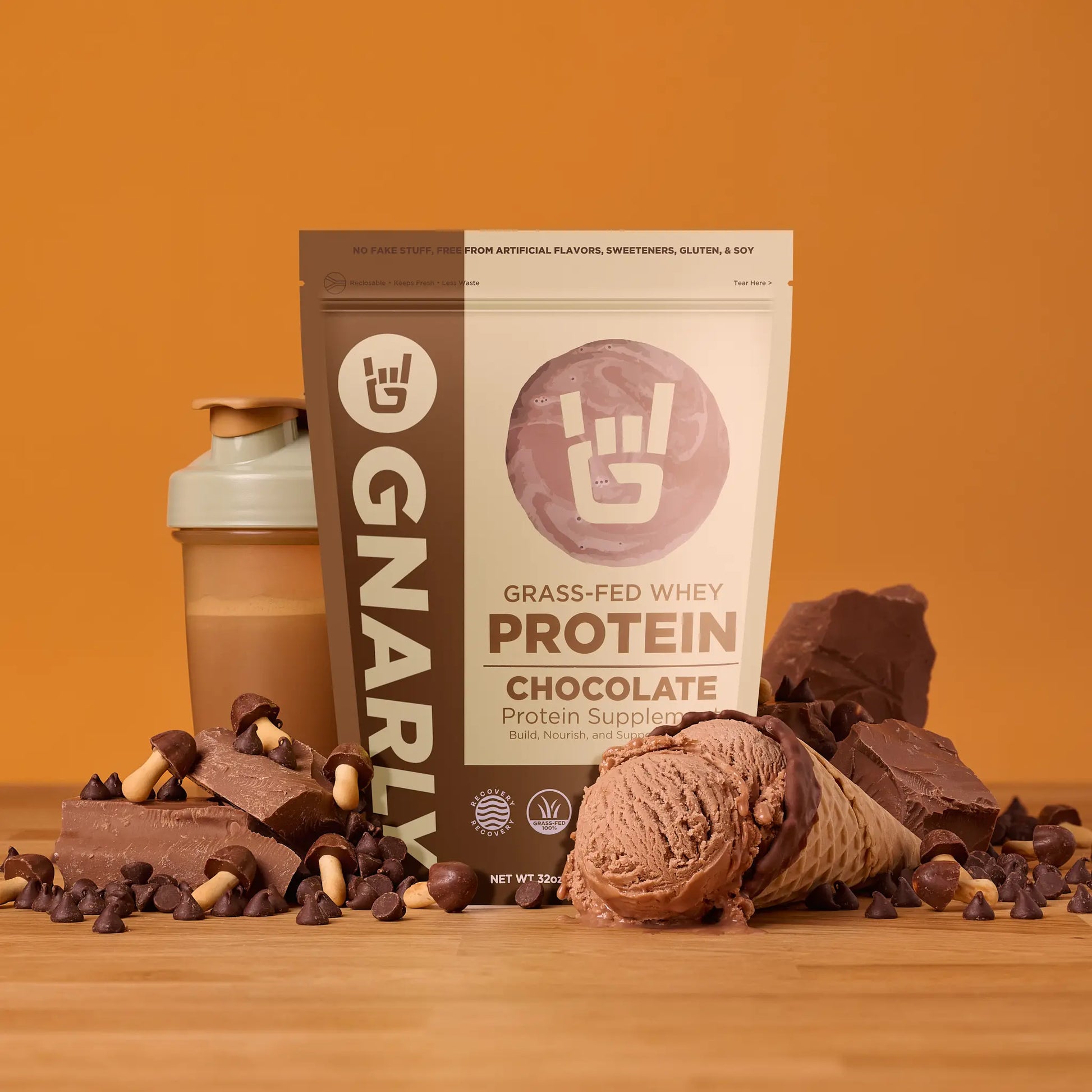 Gnarly Grass-fed Whey Chocolate Protein powder surrounded by chocolate snacks